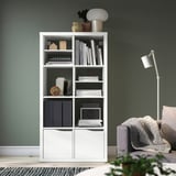 KALLAX bookshelf with decor. Grey chair, lamp. Modern home.