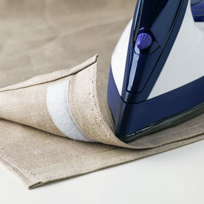 Blue iron on beige clothing, pressing and fusing fabric.