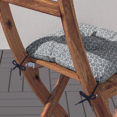 Foldable chair cushion with ties for secure placement, made from recycled polyester.