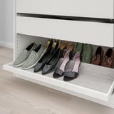 White closet shelf with various footwear neatly arranged, including heels, flats, and boots on a grey felt tray.