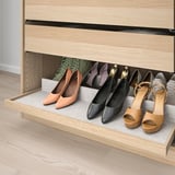 Wooden shoe rack drawer, filled with various shoes, showcasing organized storage.