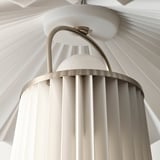 Modern hanging lamp with pleated shade and metallic arm.