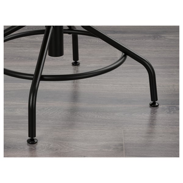 Black metal base of KULLABERG swivel chair with adjustable feet on grey floor.
