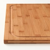 Wooden cutting board with juice groove. Crafted from bamboo, featuring a stable, milled surface.