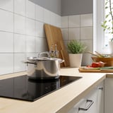 Modern kitchen with black induction cooktop and ingredients.