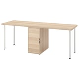 An LAGKAPTEN desk in light oak color with a storage cabinet. It a wooden top and white metal legs. The cabinet has a single door for storage.