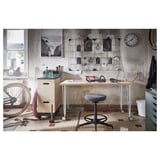 Industrial home office with LAGKAPTEN desk, bike accessories, and wall art.