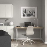 Modern home office: LAGKAPTEN desk, black chair, nyc skyline print, minimalist decor.