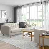 Modern living room with grey LANDSKRONA sofa, large window, wooden tables, and pillows.