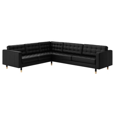 Image depicts black l-shaped leather sectional sofa with tufted seats, wooden legs.