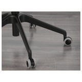 Close-up of office chair base; sturdy black arms, smooth casters, sleek grey floor.