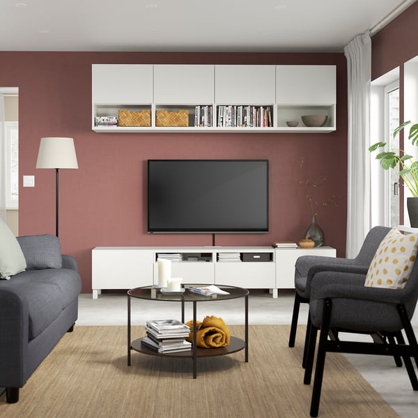 Cozy living room with red walls, gray furniture, tv, and decor.