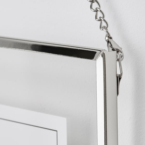 Silver-framed picture hook, securely attached to a white wall. Clear, detailed, and elegantly designed.