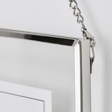 Silver-framed picture hook, securely attached to a white wall. Clear, detailed, and elegantly designed.