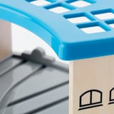 Bright blue plastic toy with holes, attached to light wooden structure.