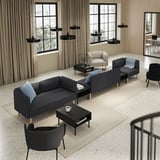 Modern living area with gray modular sofas, black coffee tables, black pendant lights, and large windows with beige curtains.
