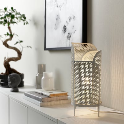Modern room with LUNNOM lamp, tree, candles, books.