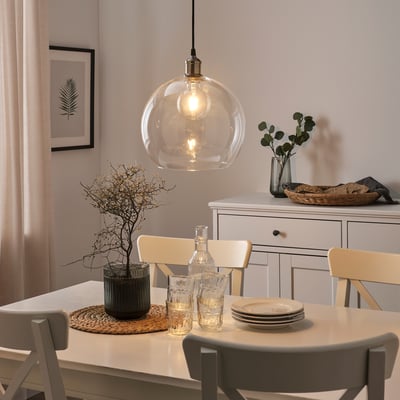Cozy dining room with glass pendant, wooden table, and floral decor.