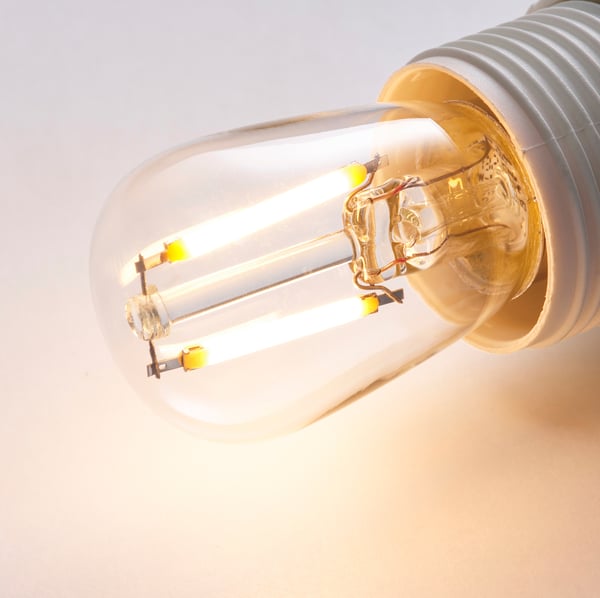 Close-up of an energy-efficient LUNNOM led bulb, showcasing its warm glow and clear glass design.