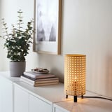 Small LUNNOM lamp with warm light sits beside a stack of books and a potted plant on a cabinet.