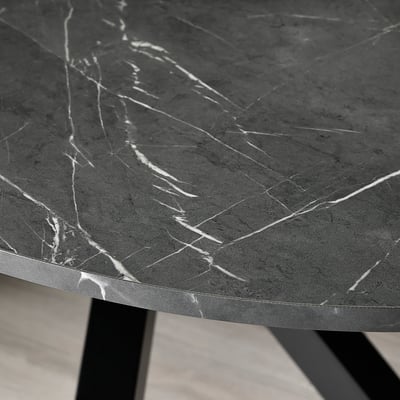 Is of a modern MARIEDAMM table, oval-shaped with a sleek black marble top. It crisscrossed metal legs, providing a sturdy and contemporary design.