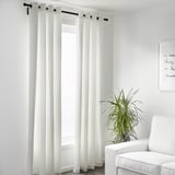 Minimalist room with MERETE light-blocking curtains on black rod, plant, and chair.