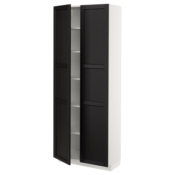A white METOD kitchen cabinet with black-stained ash doors featuring beveled edges. It includes adjustable shelves and has a traditional, warm design.