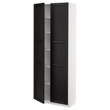 A white METOD kitchen cabinet with black-stained ash doors featuring beveled edges. It includes adjustable shelves and has a traditional, warm design.