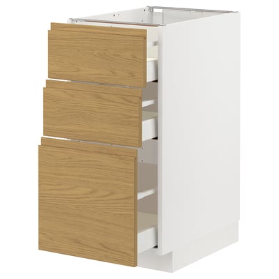 White kitchen cabinet with three wooden drawers, minimalist design.