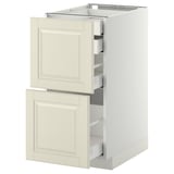 A white METOD kitchen cabinet with two off-white bodbyn drawers, featuring a traditional design with beveled edges.