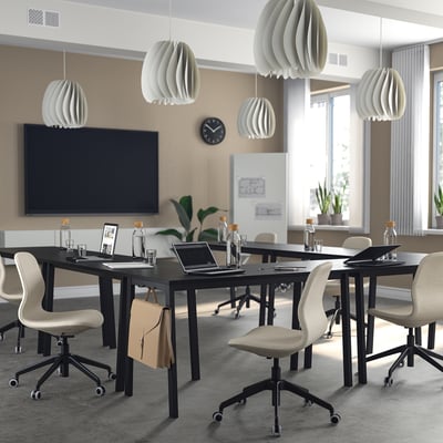 Modern office with MITTZON tables, chairs, pendant lamps, large screen, and clock.