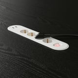White surge protector with 3 outlets, 2 usb ports on black desk.
