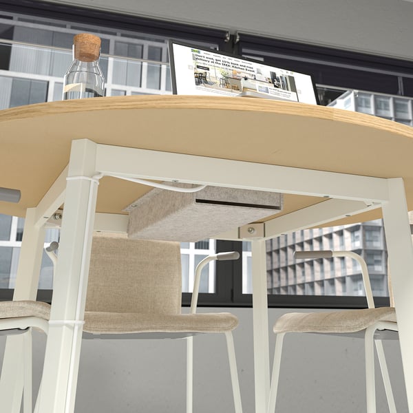Modern round office table with cable management tray and chairs.
