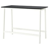 The MITTZON table has a white metal frame and a dark rectangular top. Its rectangular, durable, and easy to clean.
