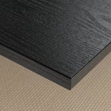 Dark wooden table top with smooth, stain-resistant finish on textured mat.