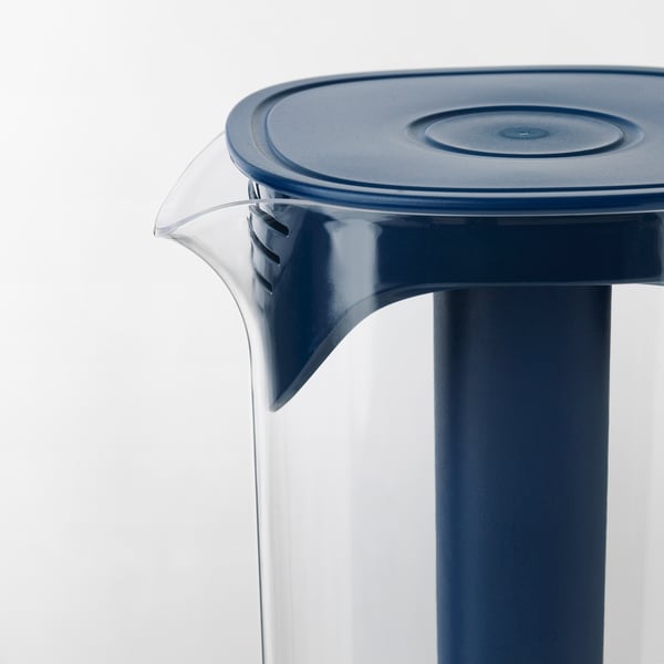 Blue plastic jug with a clear handle and a lid, designed for chilling drinks, stands upright against a white background.
