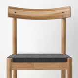Chair with curved wooden back and woven seat, showcasing natural wood grain and durable design.