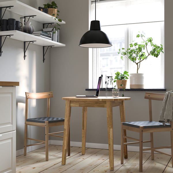 Cozy workspace with NACKANÄS table, laptop, plants, and minimalist shelves.