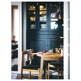 Cozy dining nook with wooden NACKANÄS table, black chairs, dark blue cabinets, and coffee setup.