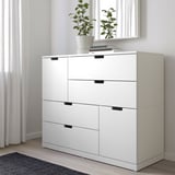White NORDLI dresser with 6 drawers, sleek modern design, fits under window, plants atop.