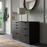 Modern dark gray NORDLI chest with mirror, lamp, plant, and coat hook.