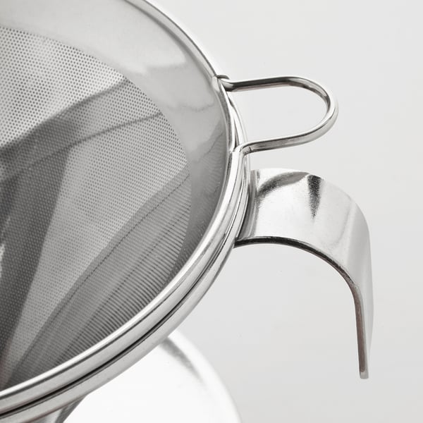 Metal mesh coffee filter with sturdy handle; sits on various containers.