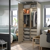 Beige PAX wardrobe with clothes and storage.