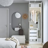 Modern bedroom with open wardrobe displaying clothes, mirror, and storage.