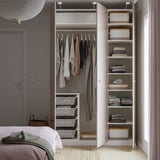 Built-in wardrobe with hanging garments, folded clothes, and mesh storage bins, featuring adjustable shelves.