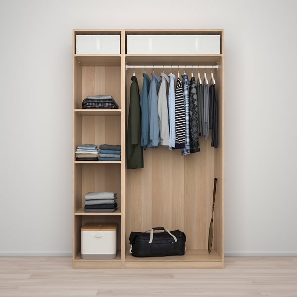 Wooden closet with clothes hangers, folded clothes, storage bins, and a duffel bag.