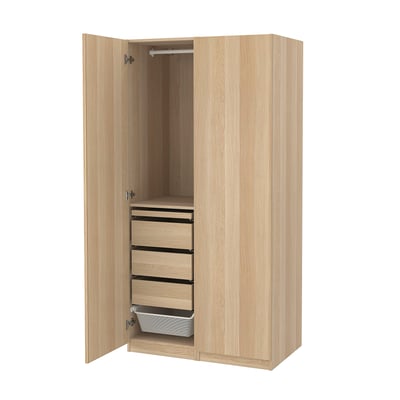 An open PAX wardrobe in light oak. It three drawers, a mesh basket, and a hanging rod. The design is modern and functional.