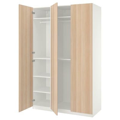 White PAX wardrobe with light wood doors, adjustable shelves, and soft-closing hinges.