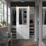 White PAX wardrobe with sliding glass doors, organized clothes, built-in lights.