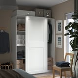 Modern bedroom with white wardrobe, gray storage, and wood chair.